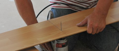Laminatdiele wird zugeschnitten