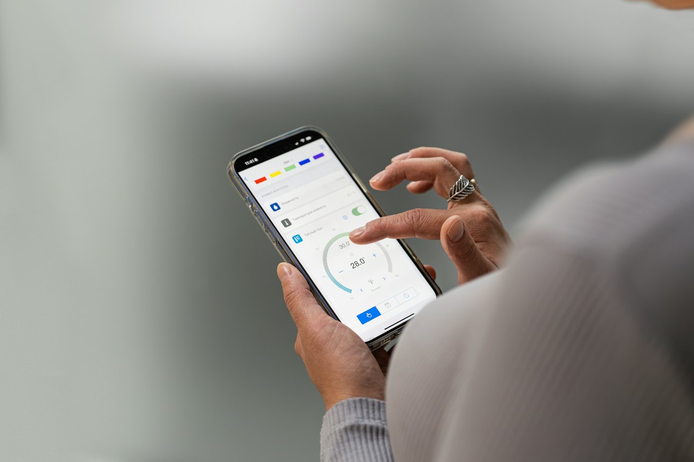 Hände halten ein Smartphone mit einer Verbrauchs-App