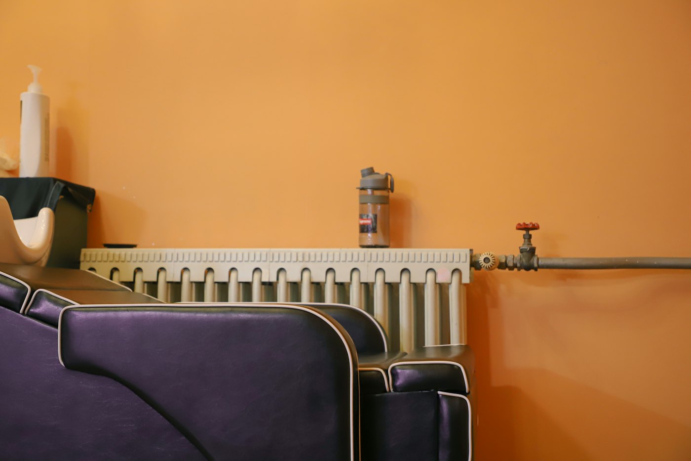 Heizkörper vor einer warmen orangefarbenen Wand im Wohnzimmer
